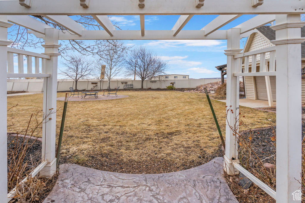 View of yard with a patio area, fence, and a pergola