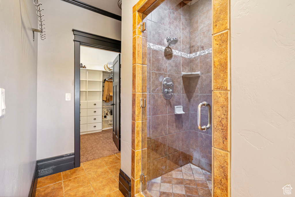 Full bath featuring baseboards, a shower stall, and tile patterned floors