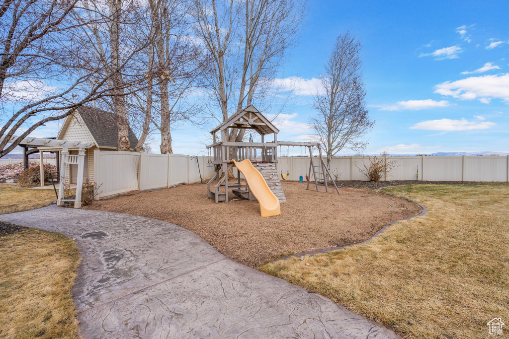 View of playground featuring a yard and fence private yard