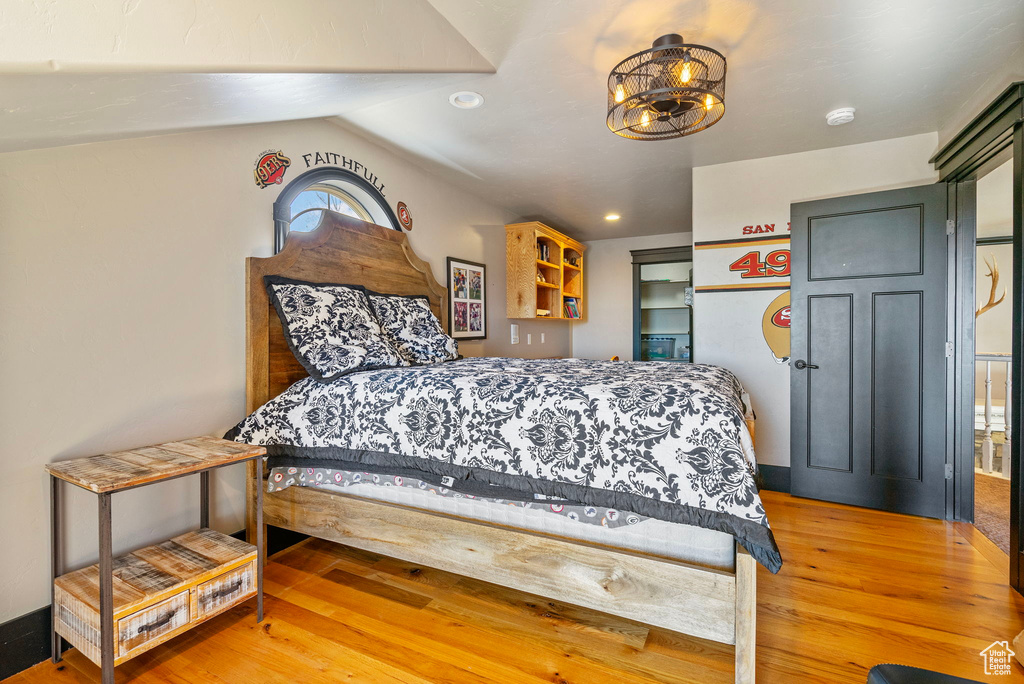 Bedroom featuring vaulted ceiling, recessed lighting, a notable chandelier, and light wood-style floors