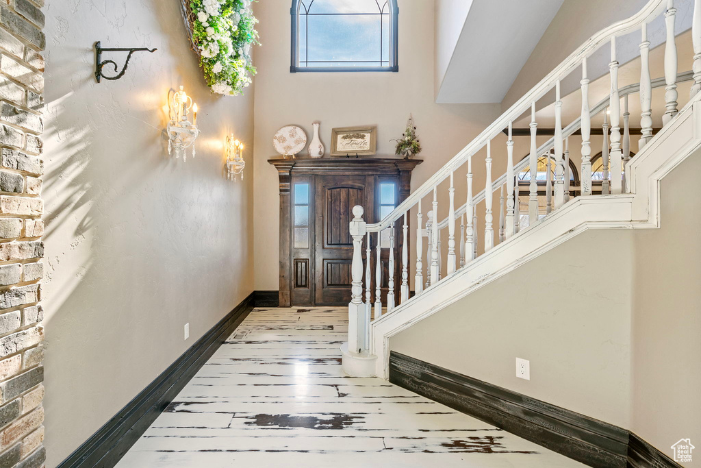 Foyer featuring hardwood / wood-style flooring, baseboards, and stairway