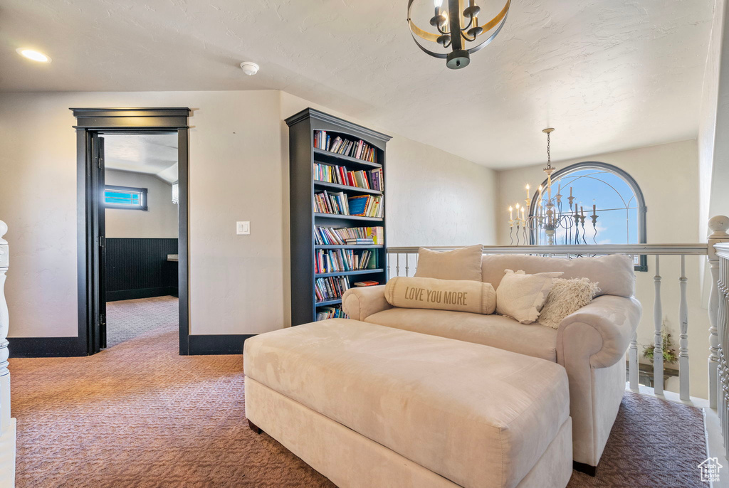 Living area with a notable chandelier and carpet flooring