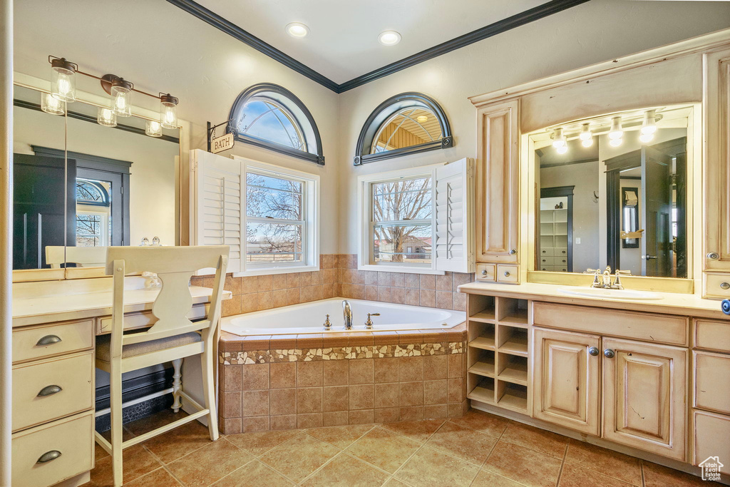 Full bath with tile patterned flooring, a garden tub, vanity, and crown molding