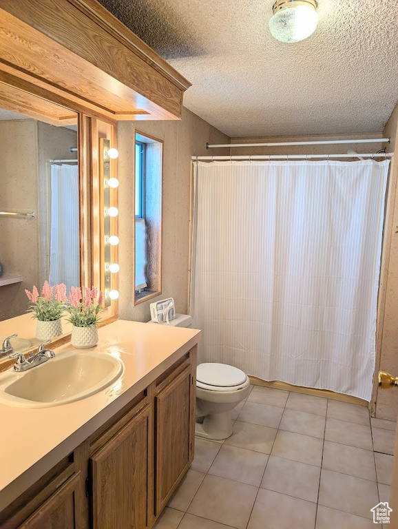 Bathroom with toilet, tile patterned flooring, a textured ceiling, and vanity