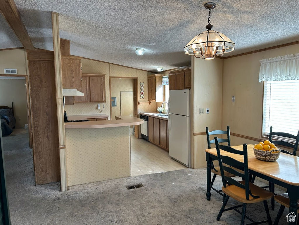 Kitchen with light colored carpet, dishwashing machine, freestanding refrigerator, under cabinet range hood, and a sink