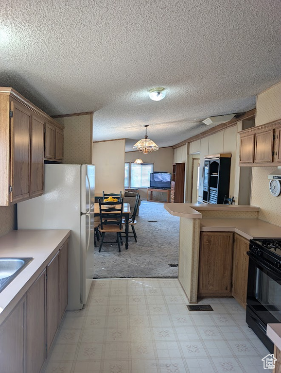 Kitchen featuring light floors, black range with gas stovetop, light countertops, and pendant lighting