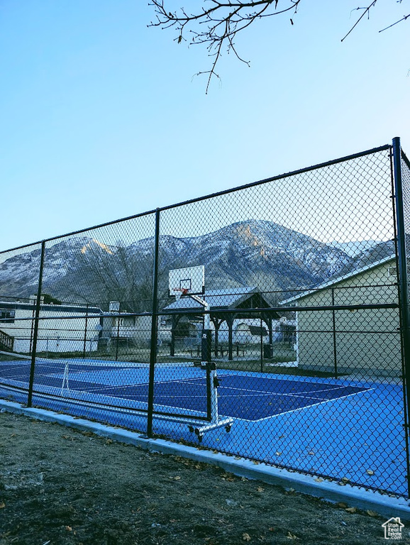 View of sport court featuring community basketball court, a mountain view, and fence
