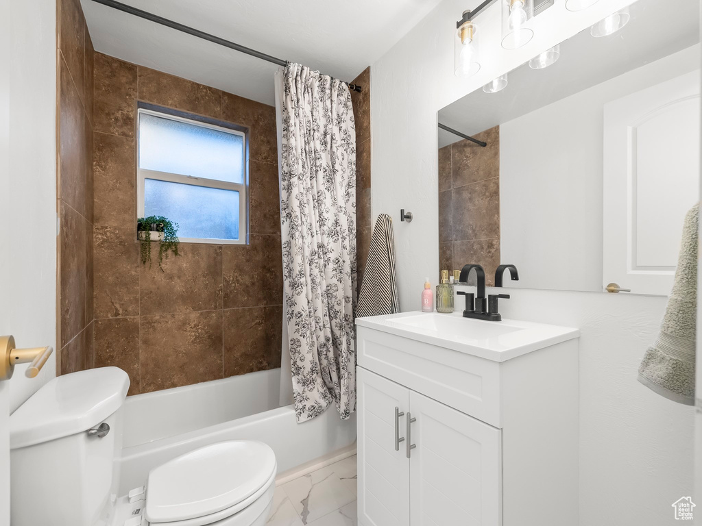 Full bathroom featuring marble finish floor, vanity, toilet, and shower / bathtub combination with curtain