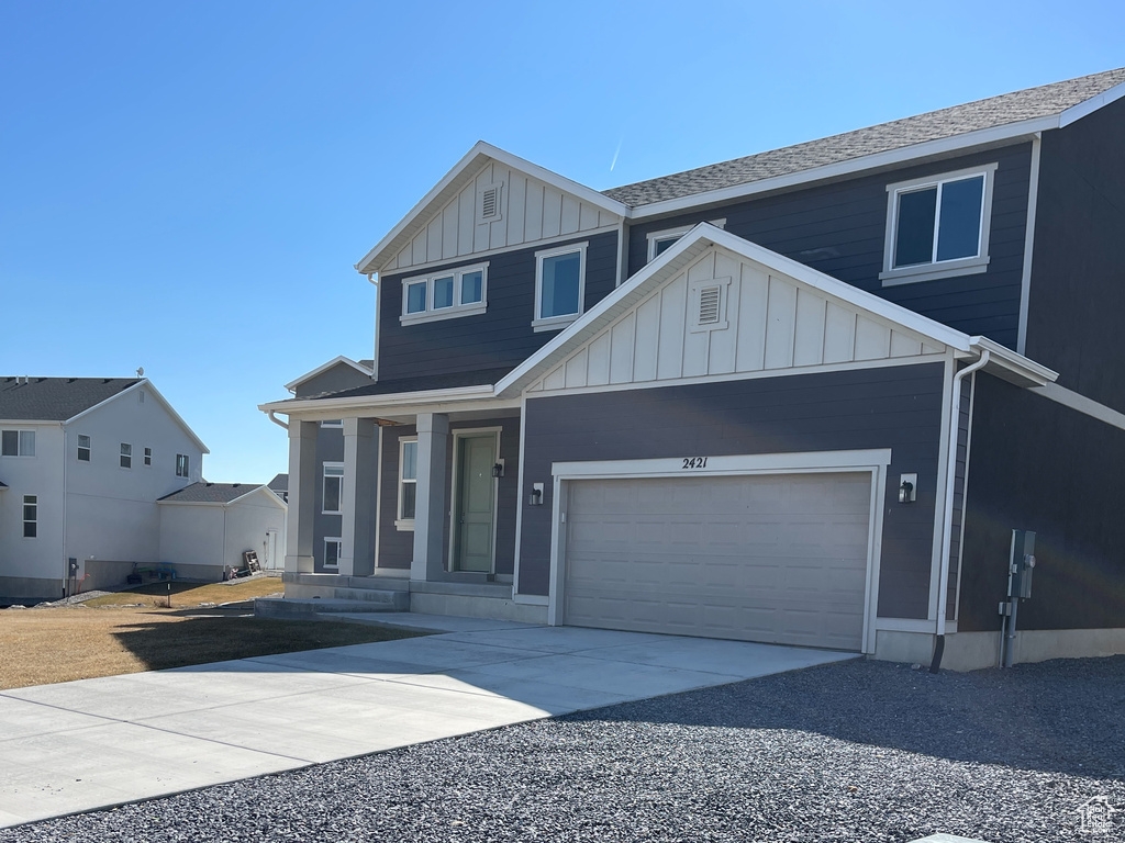 View of front of home featuring an attached garage, board and batten siding, and driveway