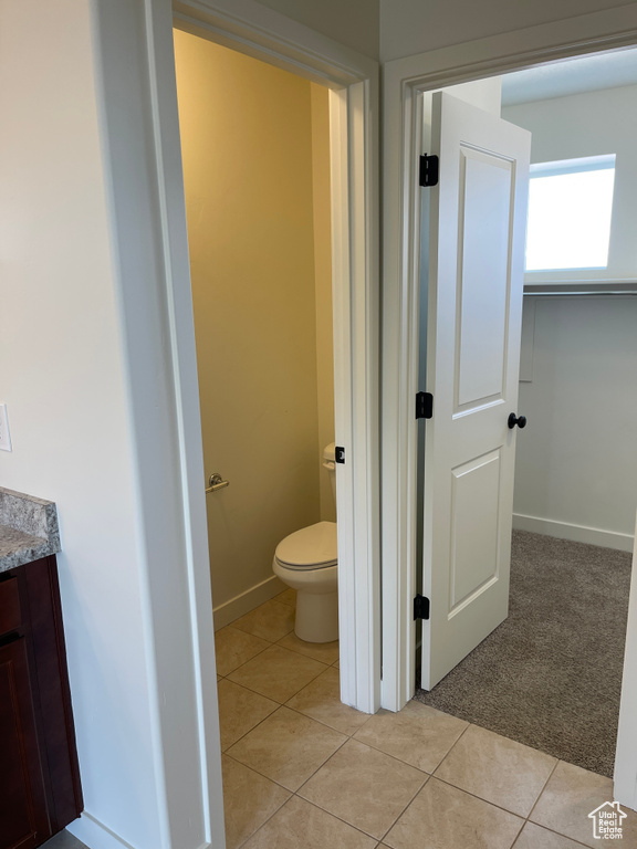 Bathroom with vanity, tile patterned floors, toilet, and baseboards