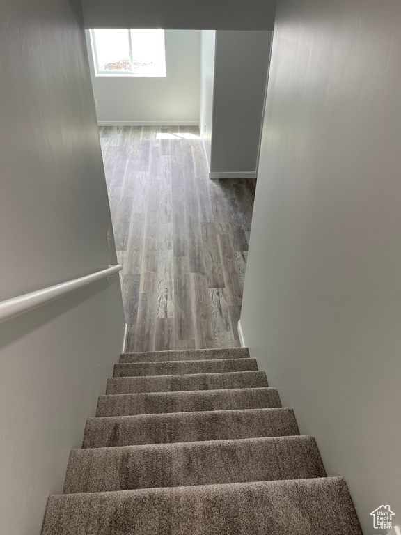 Stairway with baseboards and wood finished floors