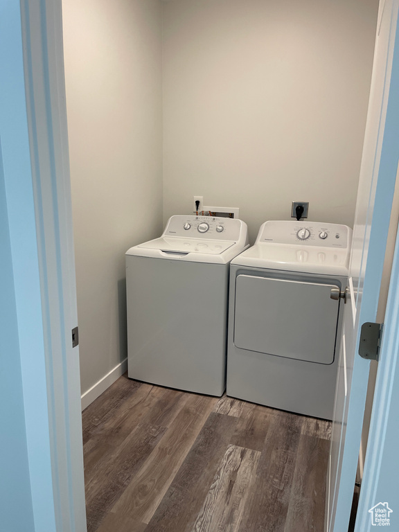 Laundry area featuring independent washer and dryer, wood finished floors, laundry area, and baseboards
