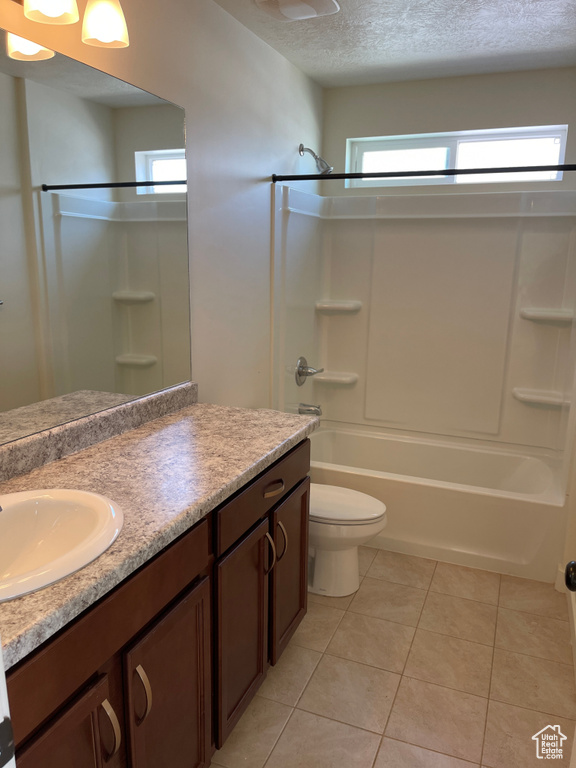 Full bathroom with plenty of natural light, a textured ceiling, vanity, and tile patterned flooring