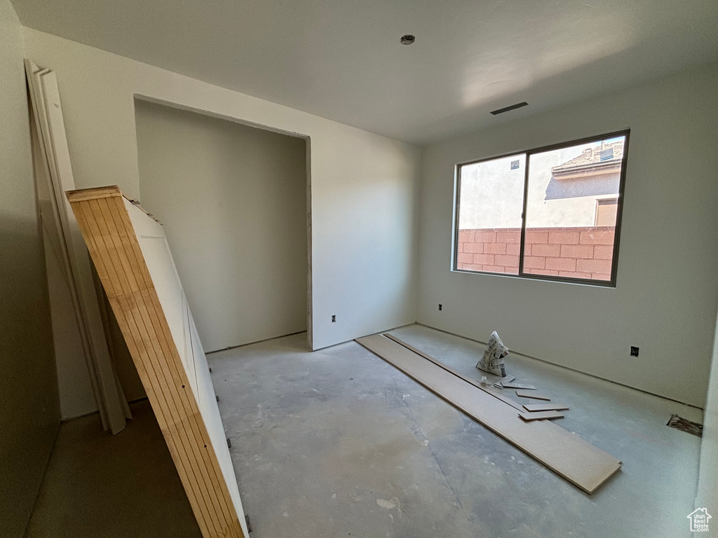 Unfurnished bedroom with unfinished concrete floors
