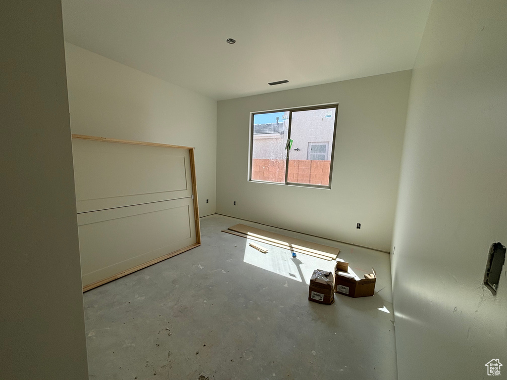 Unfurnished bedroom with unfinished concrete floors