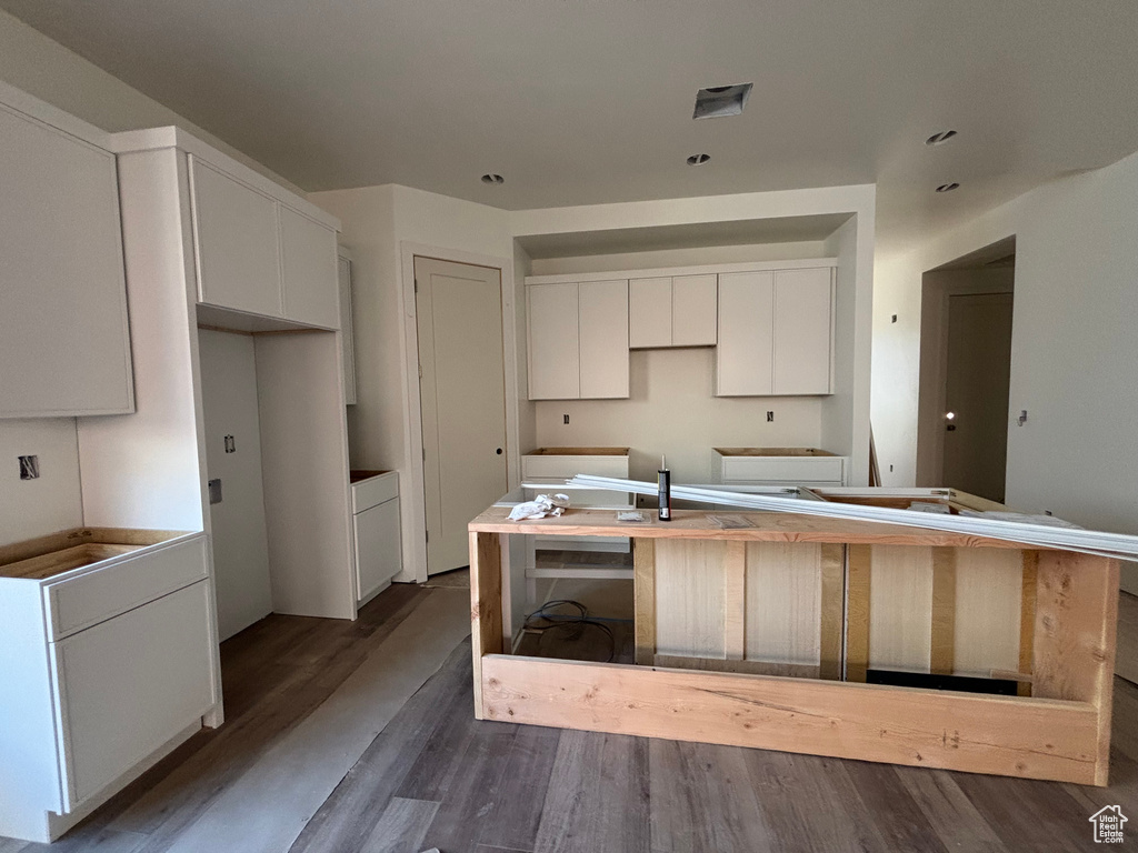Kitchen with dark wood-style floors, white cabinetry, and a kitchen island