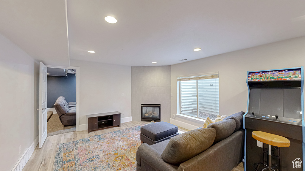 Living area featuring visible vents, recessed lighting, a fireplace, and light wood-style floors