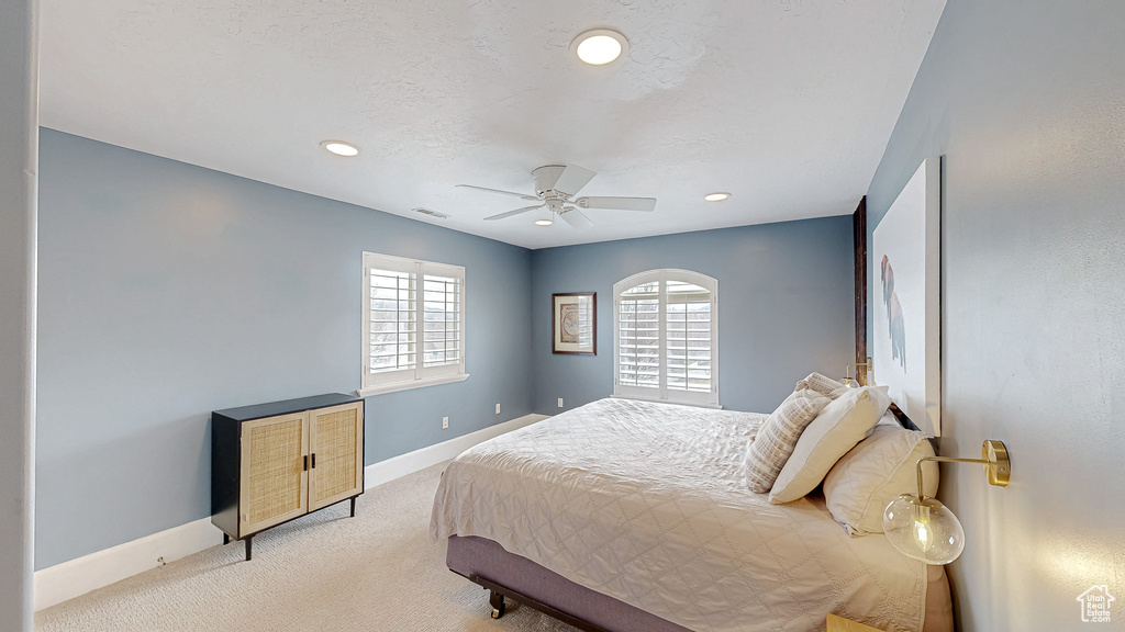 Bedroom featuring visible vents, light carpet, recessed lighting, baseboards, and ceiling fan