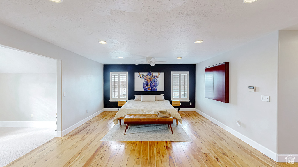 Unfurnished bedroom featuring recessed lighting, a textured ceiling, light wood-type flooring, and baseboards