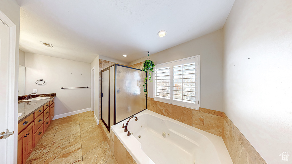 Full bathroom featuring visible vents, a shower stall, double vanity, a tub with jets, and a sink