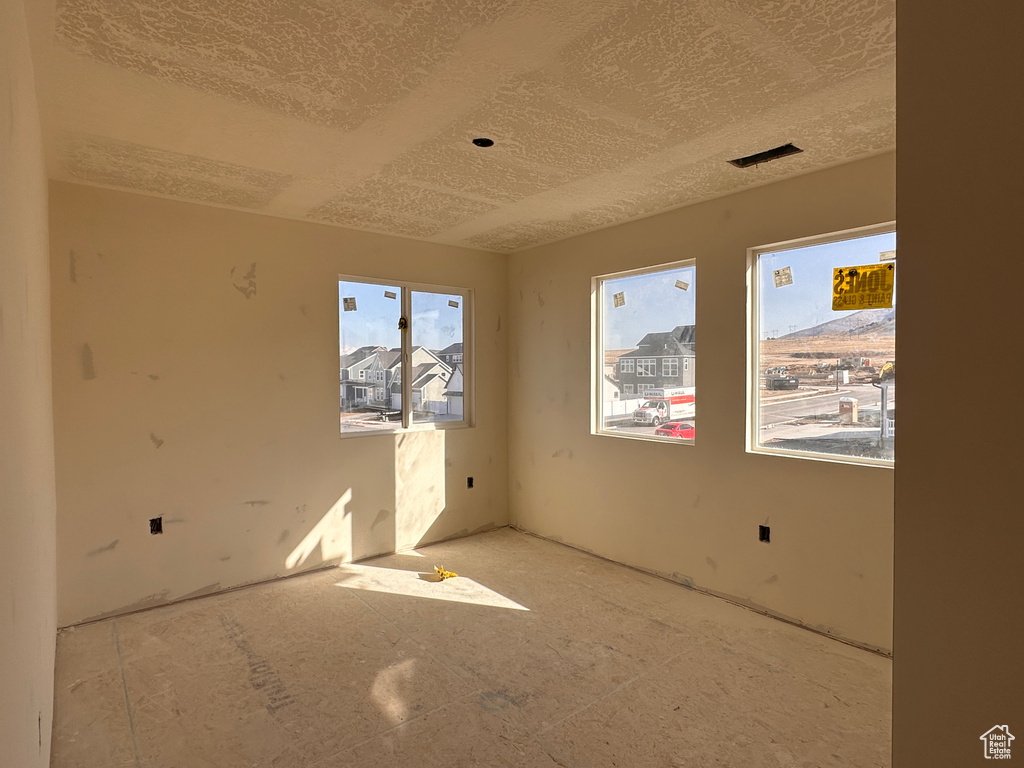 Spare room featuring plenty of natural light and a textured ceiling