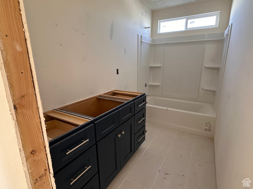 Full bath featuring tile patterned flooring, vanity, and bathtub / shower combination