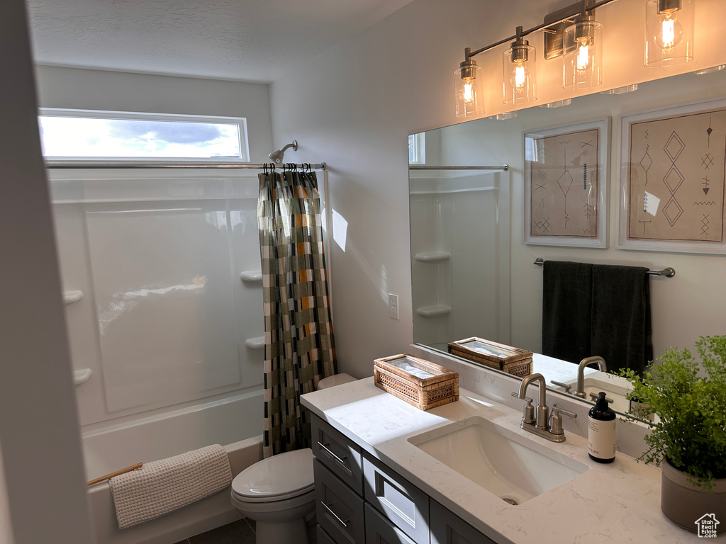 Full bathroom featuring vanity, shower / tub combo, and toilet