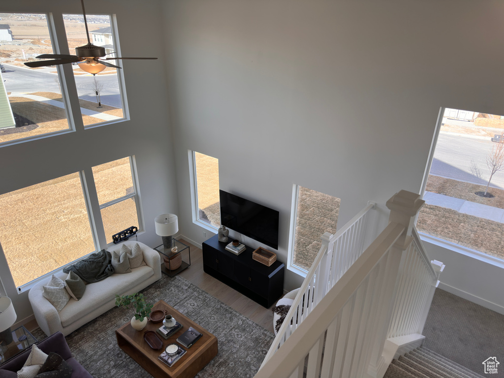 Living room featuring a ceiling fan, baseboards, and wood finished floors