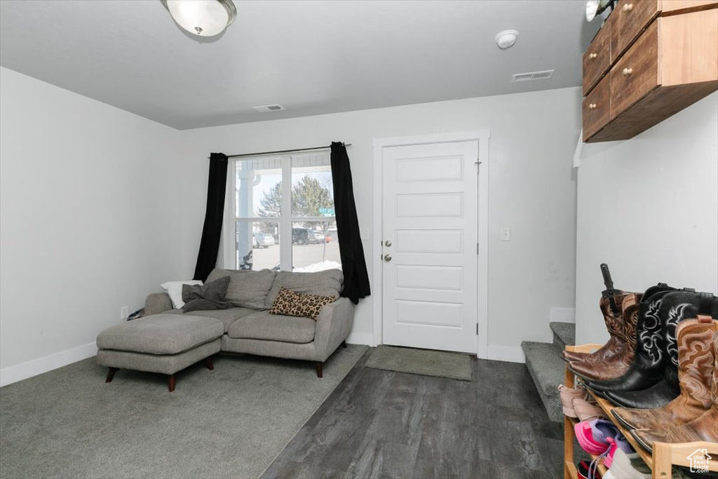 Living room with visible vents, baseboards, and stairs