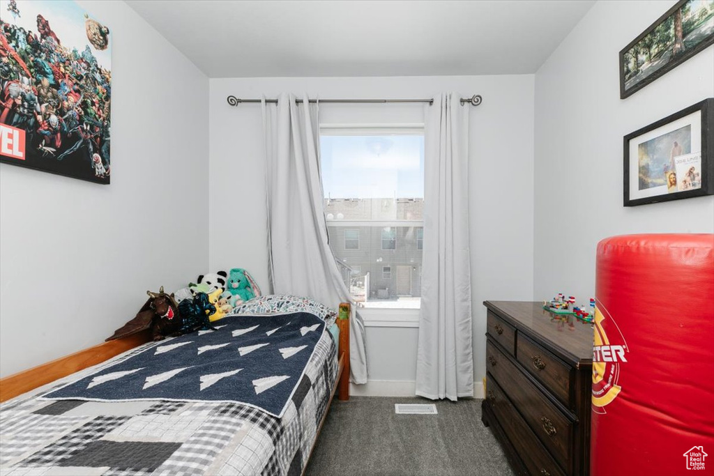 Bedroom featuring baseboards and dark colored carpet