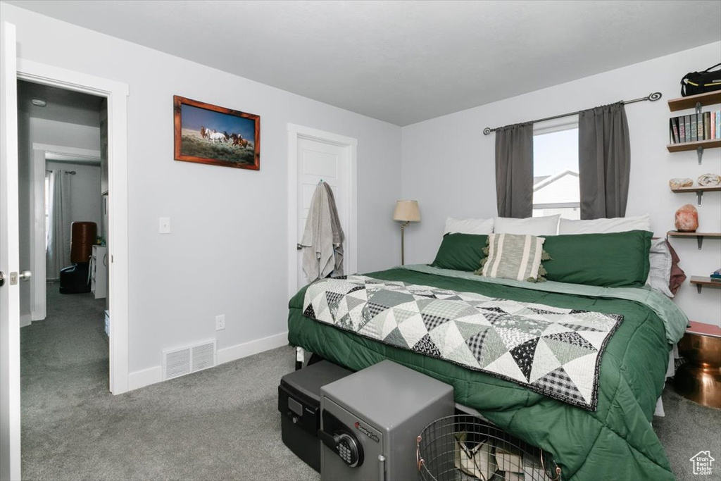 Carpeted bedroom featuring visible vents and baseboards