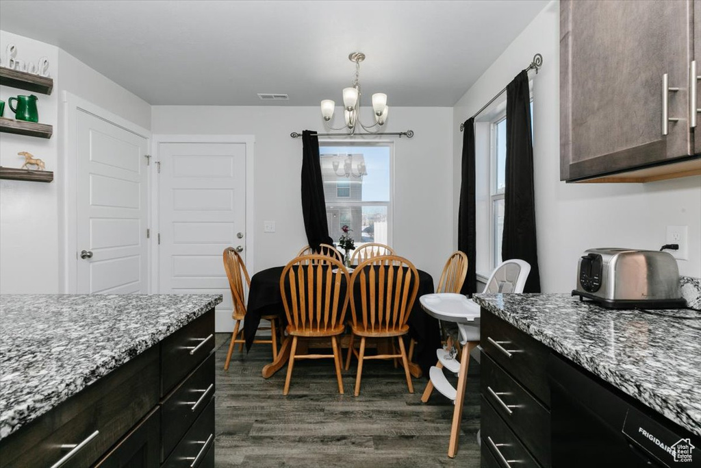 Dining space featuring visible vents, dark wood-type flooring, and a chandelier
