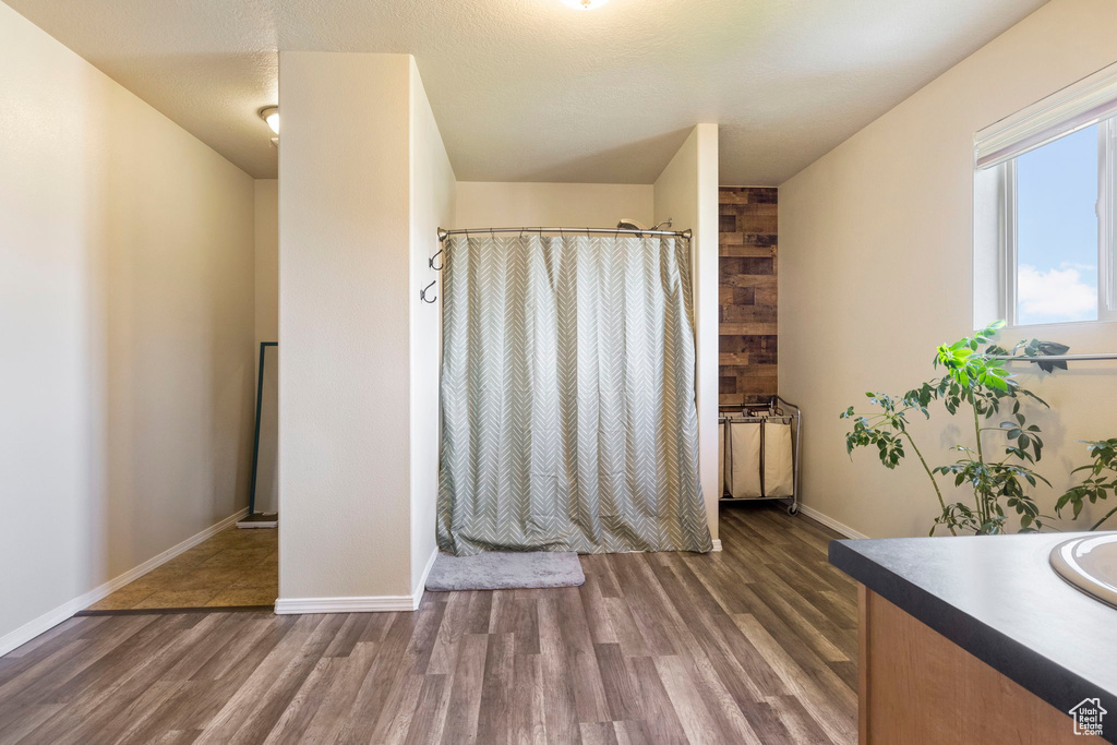 Full bathroom featuring vanity, a shower with shower curtain, baseboards, and wood finished floors