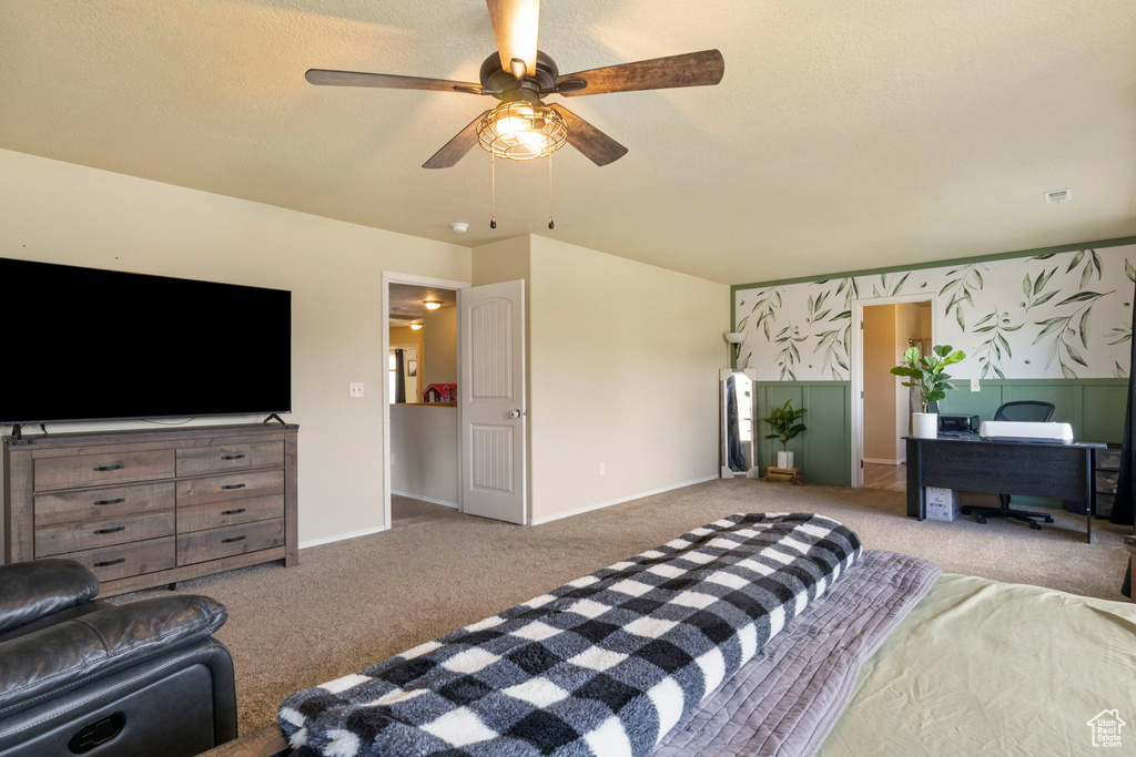 Carpeted bedroom featuring wallpapered walls, a ceiling fan, baseboards, and a textured ceiling