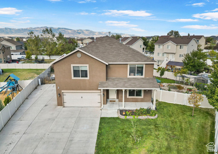 Traditional-style home with a front lawn, a porch, fence private yard, stucco siding, and an attached garage