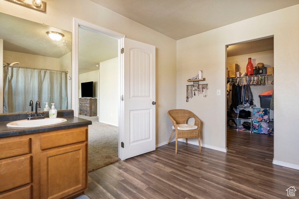 Bathroom with vanity, a shower with shower curtain, wood finished floors, and baseboards