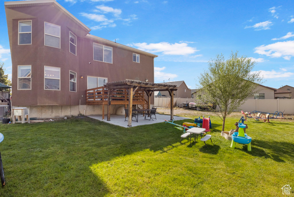 Back of house featuring a patio area, a yard, a pergola, and a fenced backyard