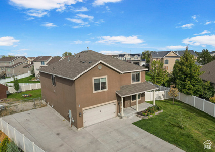 View of front of property with a fenced backyard, stucco siding, a front lawn, a garage, and a residential view