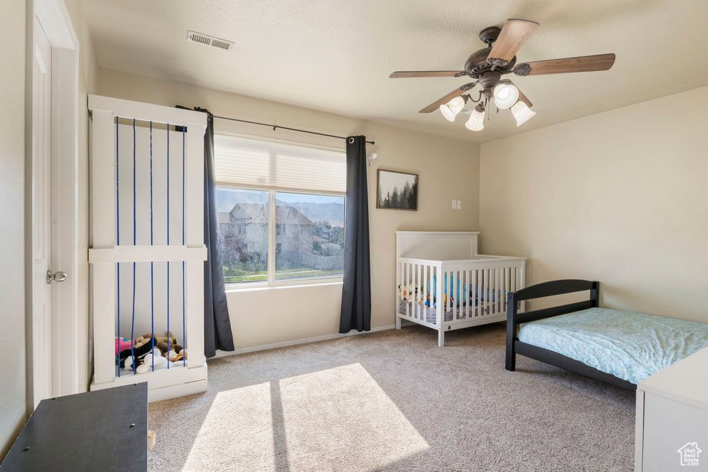 Bedroom featuring visible vents, a ceiling fan, and carpet