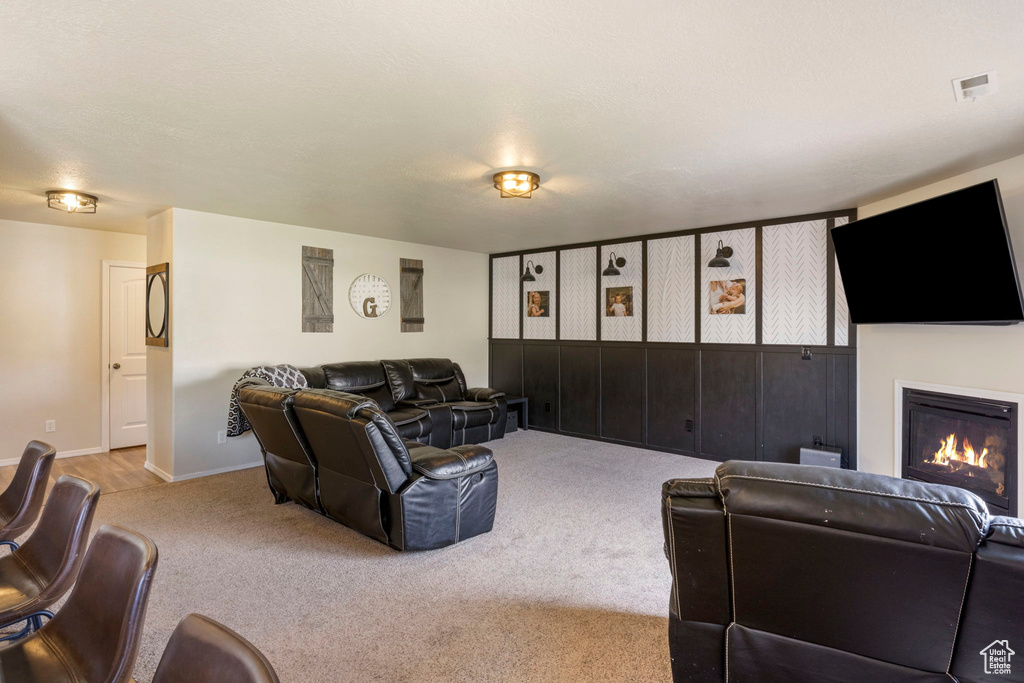 Living area featuring visible vents, carpet floors, baseboards, and a glass covered fireplace