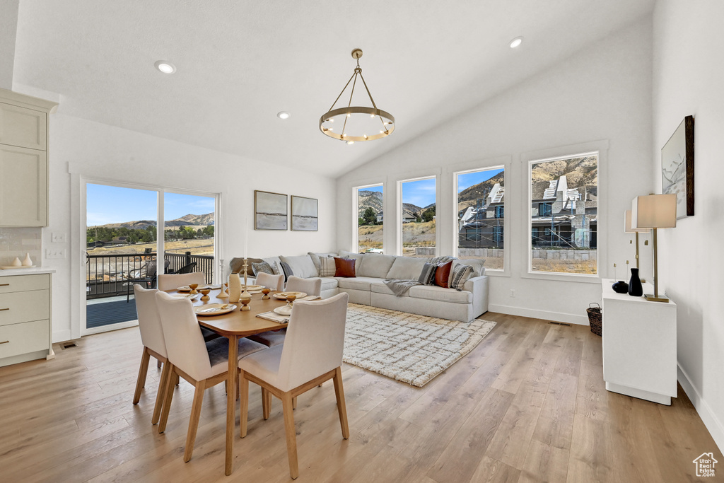 Dining space featuring recessed lighting, baseboards, high vaulted ceiling, and light wood-style flooring