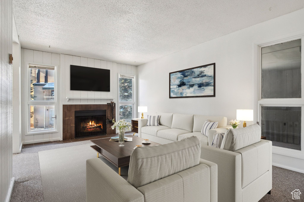 Carpeted living area with a fireplace and a textured ceiling