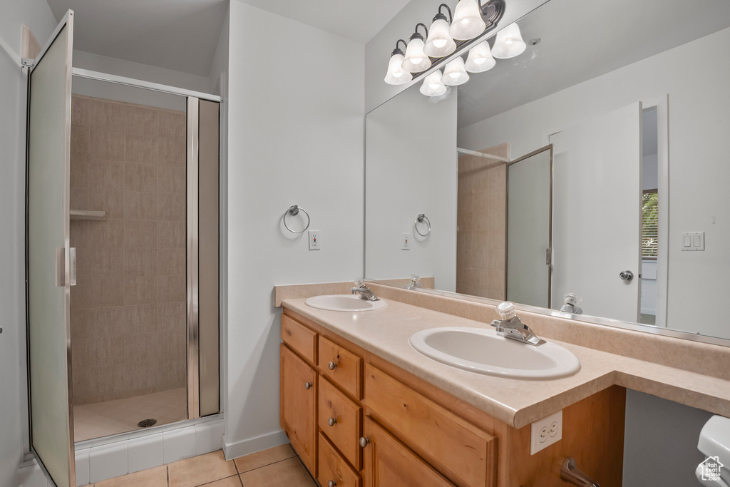 Full bath featuring a shower stall, tile patterned flooring, and double vanity