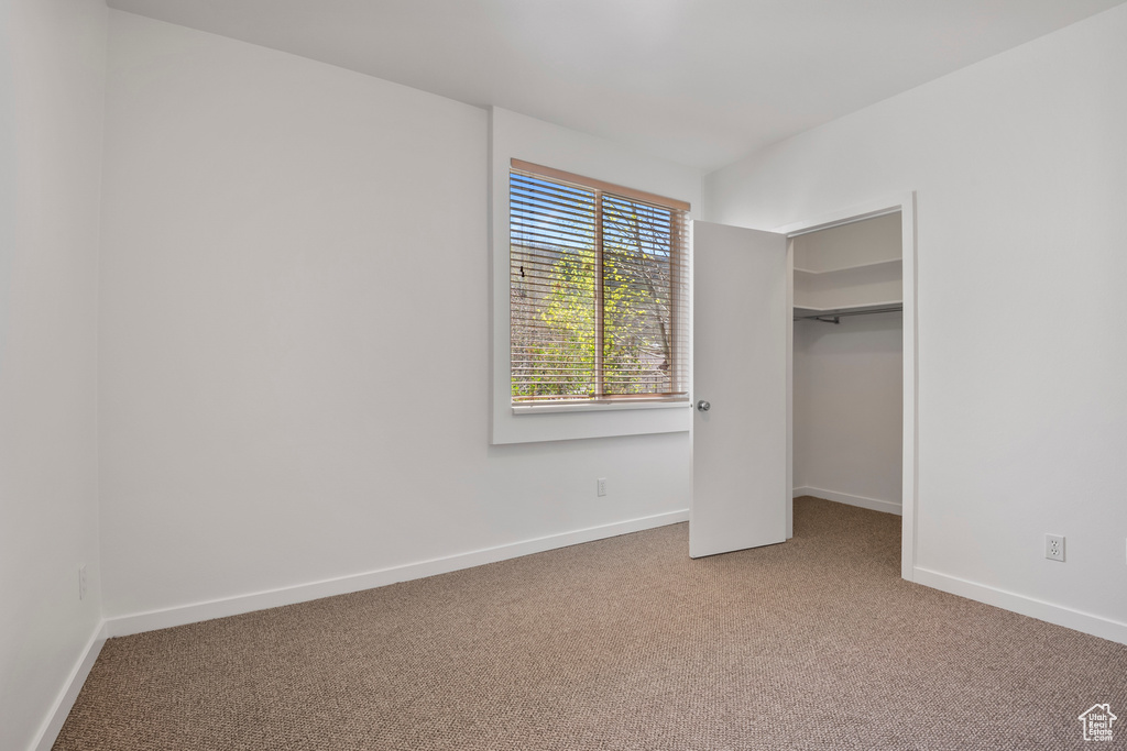 Unfurnished bedroom featuring carpet and baseboards
