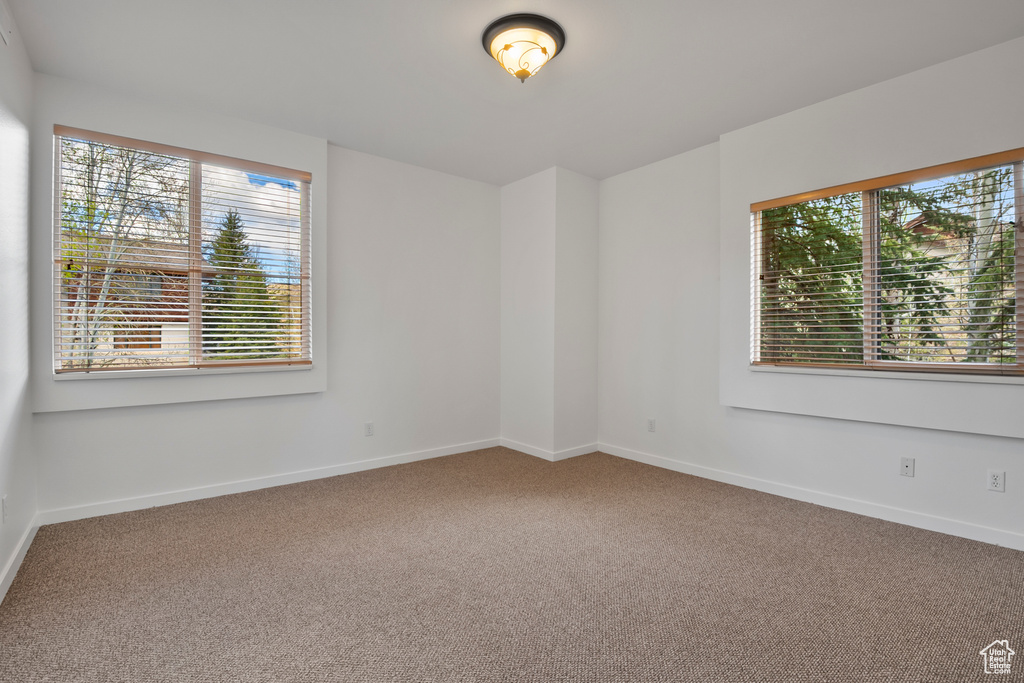 Empty room featuring carpet floors and baseboards