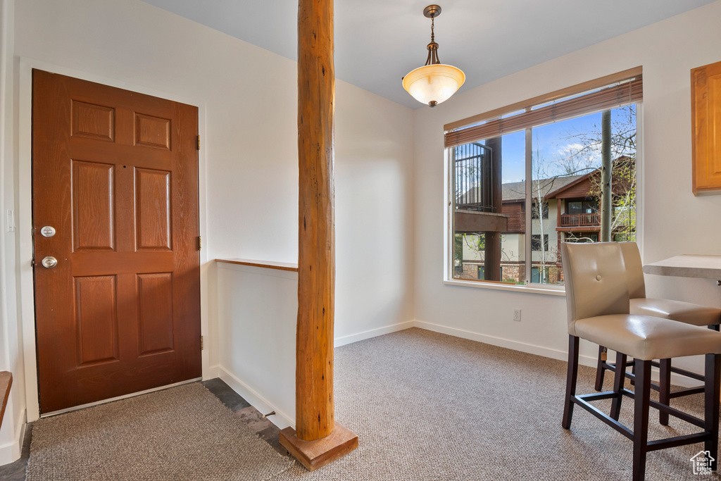 Carpeted foyer with baseboards
