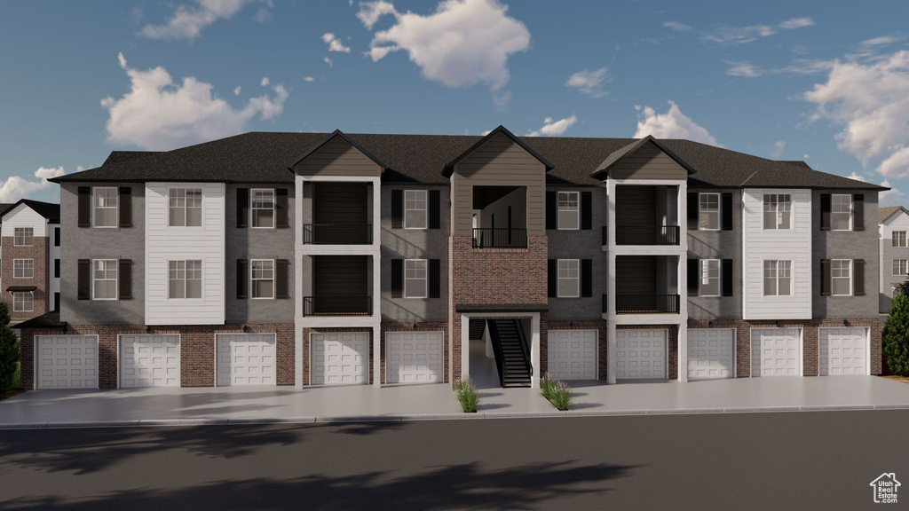 Multi unit property featuring an attached garage, brick siding, and a residential view