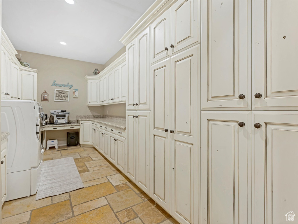 Washroom with recessed lighting, cabinet space, washer / dryer, and stone tile floors