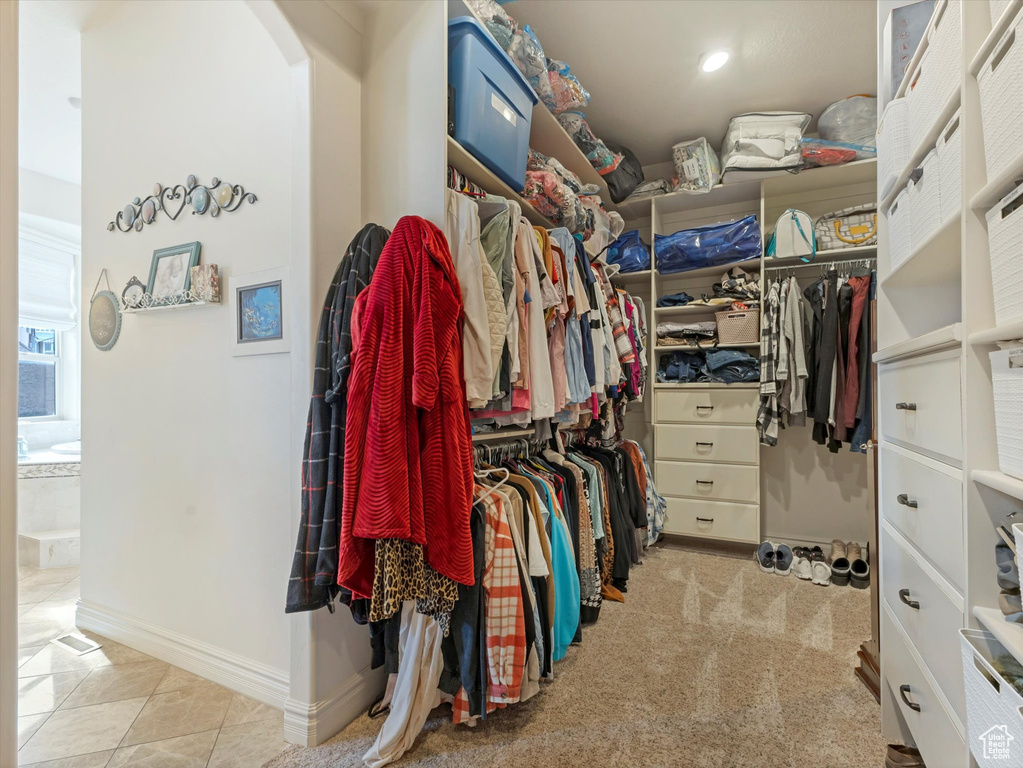 Spacious closet with tile patterned flooring and arched walkways