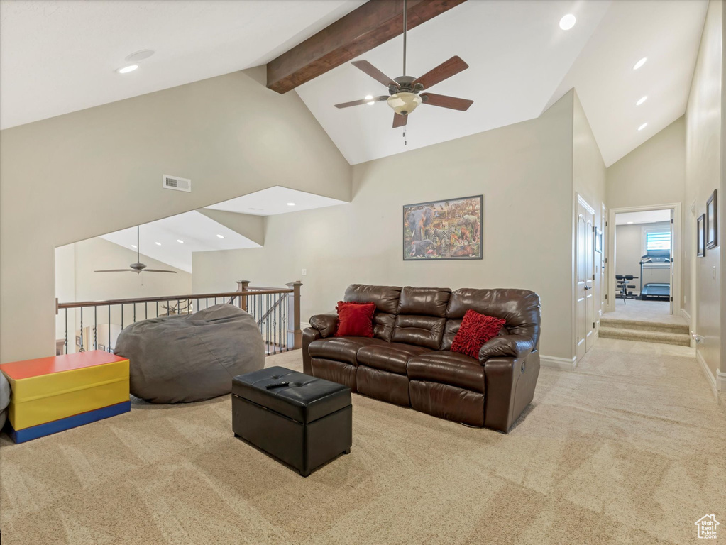 Living room featuring visible vents, baseboards, beamed ceiling, carpet flooring, and high vaulted ceiling